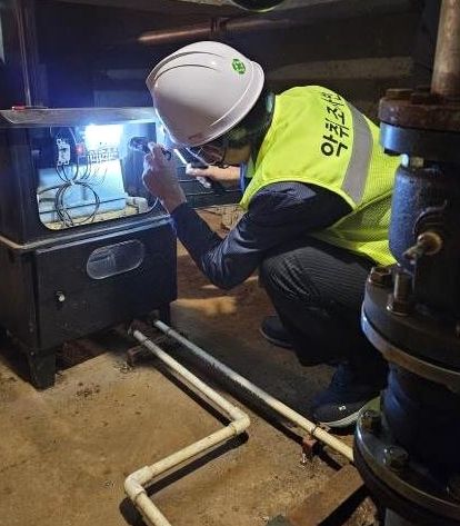 정화조에 설치된 악취 저감시설을 점검하고 있는 모습