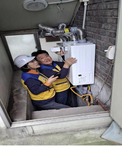 ㈜KR귀뚜라미 보일러 권성심 대표(좌)와 사랑의 보일러 나눔 안용묵 대표(우)가 구립 경로당 보일러를 점검하며 가스 경보기를 부착하고 있다.