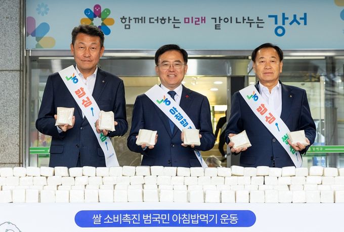 진교훈 서울 강서구청장이 구청 정문 앞에서 열린 우리쌀 소비 촉진을 위한 ‘아침밥 먹기 운동’ 캠페인에서 백설기를 들어 보이고 있다. 왼쪽부터 김상수 농협중앙회 서울본부장, 진 구청장, 장순석 강서농업협동조합장