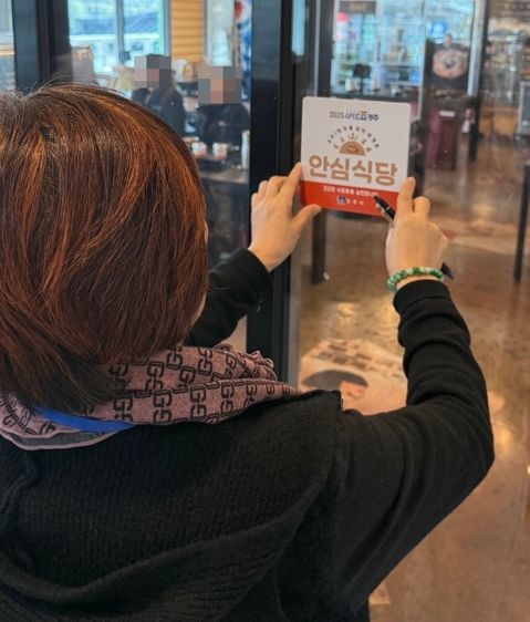 지역의 어느 한 식당에서 리뉴얼 된 안심식당 지정 표지판을 부착하고 있다.