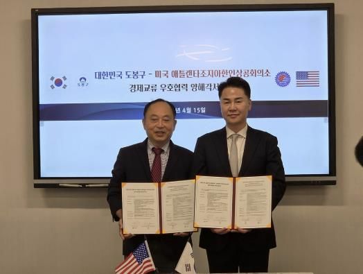 오언석 도봉구청장(오른쪽)과 썬 박 세계한인무역협회 월드옥타 애틀랜타 지회장(왼쪽)이 양해각서를 들고 기념 촬영을 하고 있다