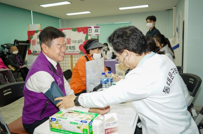 이필형 동대문구청장(사진 왼쪽)이 지난해 ‘어르신 동백꽃(동대문구에서 백 살까지 꽃처럼 살자) 프로젝트’ 현장에 참여한 모습