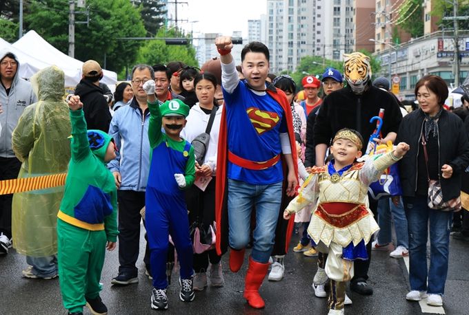 슈퍼맨으로 변신한 오언석 도봉구청장이 아이들과 함께 캐릭터 퍼레이드를 선보이고 있다