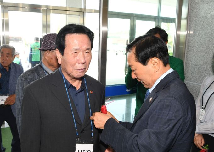 성낙인 창녕군수가 어버이날 행사에서 어르신들에게 카네이션을 달아드리며 감사의 뜻을 전하고 있다.