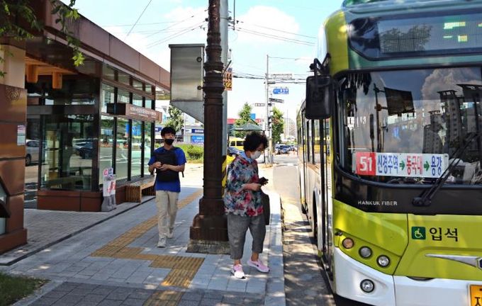 시내버스 정류장에서 시민들이 버스에 탑승하고 있다.