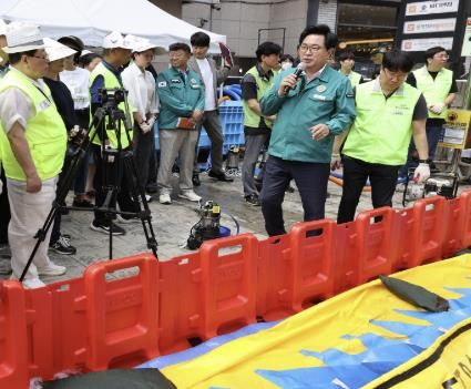 박일하 구청장이 지난 18일 서울 동작구 성대전통시장에서 열린 “집중호우 대비 수방장비 교육 및 훈련”에 참석해 주민들에게 장비 사용법을 직접 설명하고 있다.