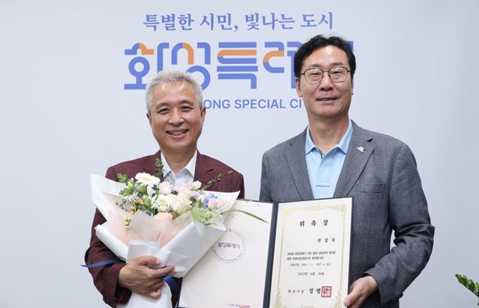 정명근 화성특례시장(오른쪽)이 28일 시청에서 곽상욱 (사)ESG대한민국정원정책포럼 이사장(왼쪽)에게 화성특별정원 특별자문위원 위촉장을 전달하고 기념촬영을 하고 있다