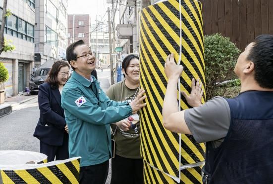 어린이집 앞 전신주에 안전보호대를 설치하고 있는 최호권 영등포구청장