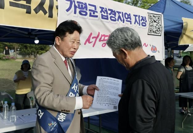 서태원 군수가 2024년 실시한 '범군민 서명운동'에서 주민으로부터 접경지역 서명을 받고 있다