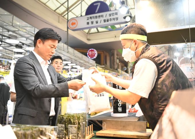 조용익 부천시장이 30일 상동시장을 방문해 민생경제를 현장에서 살피고 부천페이로 장을 보고 있다.