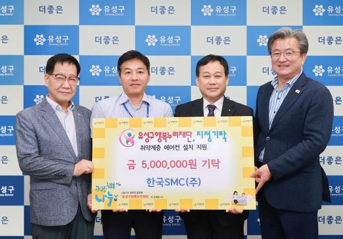 2일 한국SMC가 여름철 폭염 대비 후원금 500만 원을 기탁하고 민경호 공장장(오른쪽에서 두번째)과 김다운 팀장(왼쪽에서 두번째)이 후원금을 기탁하고 정용래 유성구청장(오른쪽)과 기념촬영을 하고 있다.