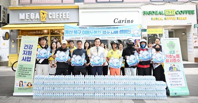 북구와 북구비정규직노동자지원센터는 10일 화봉시장 사거리 일원에서 폭염에 취약한 배달대행업체 이동노동자에게 생수를 전달했다. 박천동 북구청장이 배달대행업체에 생수를 전달한 후 기념촬영을 하고 있다.