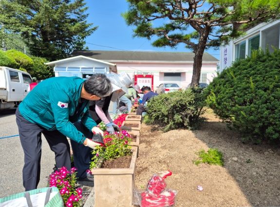 김용문 밀양시 단장면장과 직원 및 자활근로자들이 11일 단장면 행정복지센터와 도로변 화분에 여름꽃을 심고 있다.