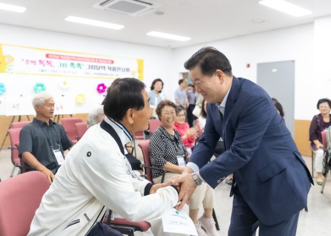 박승원 광명시장(사진 오른쪽)이 16일 ‘우리동네 시장실’의 일환으로 학온동을 방문해 학온동 지역사회보장협의체 특화 사업인 ‘추억 톡톡, 그림 쏙쏙’ 참여 어르신과 인사를 나누고 있다.