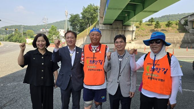 임동주 경주시 문화관광국장이 만불사 입구에서 이범식 박사의 도보 종주를 응원하며 기념쵤영을 하고 있다.