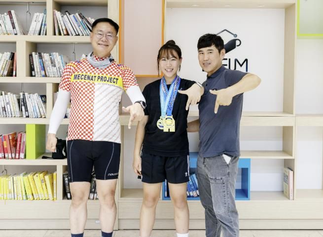 퇴근길에 응원 온 군수와 함께”김재욱 칠곡군수(왼쪽)가 퇴근길에 전국레슬링대회 3연속 우승을 차지한 약동초 6학년 임하경 양(가운데)을 격려하고 있다. 오른쪽은 아버지 임종구 씨.