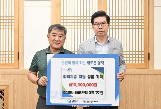 주식회사 에이치앤티 고기한 대표(왼쪽)가 김광열 영덕군수를 만나 성금을 전달하고 있다.