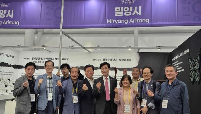 안병구 밀양시장과 관계자들이 2025 영동 세계 국악 엑스포 밀양아리랑 홍보관 앞에서 기념 촬영을 하고 있다.
