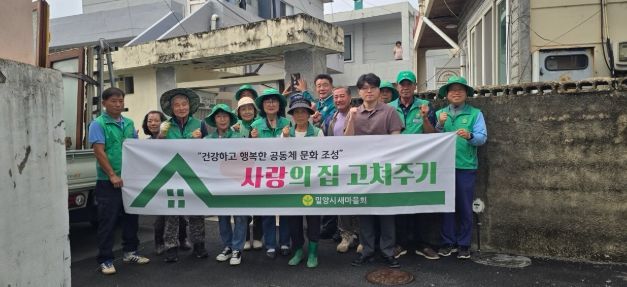 24일 밀양시새마을회가 사랑의 집 고쳐주기 활동 기념 단체 촬영을 하고 있다.