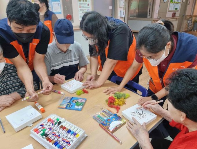 밀양시가족센터 나우누리 가족봉사단이 명성요양원을 방문해 어르신들을 위한 정서지원 봉사활동을 진행하고 있다.