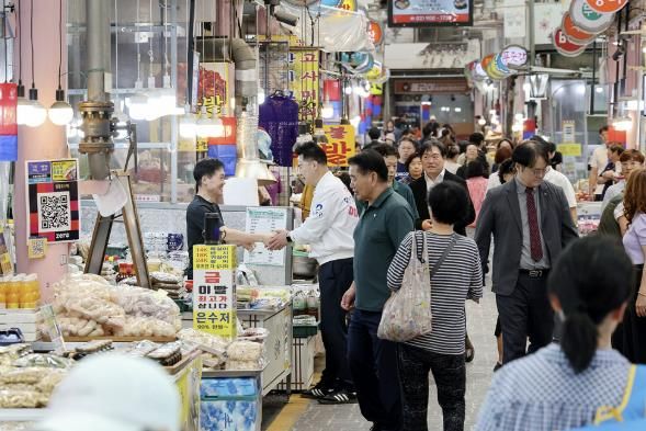 오언석 도봉구청장이 지난 26일 지역 내 한 전통시장을 찾아 상인과 손을 맞잡고 있다.