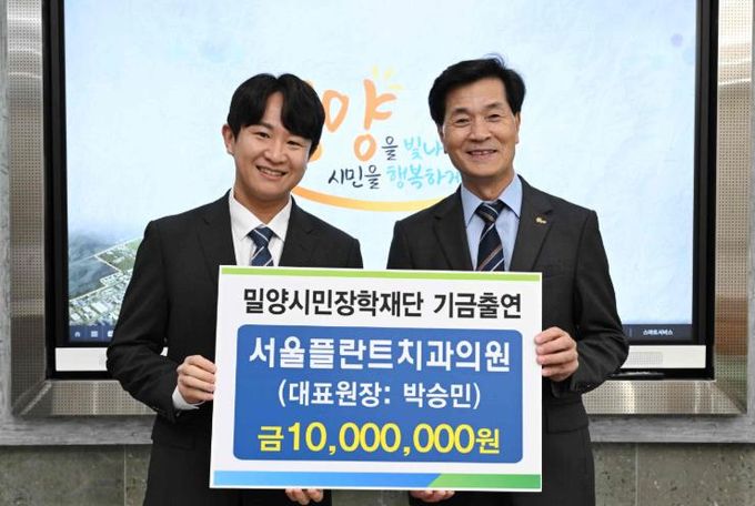 박승민 서울플란트치과의원 대표원장(왼쪽)이 13일 밀양시장실을 방문해 장학기금 1,000만원을 전달하고 있다.