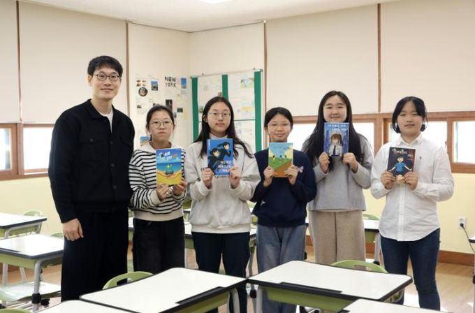 독서토론 동아리 학생들이 22일 자신이 출간한 책을 들고 기념사진을 찍고있다.